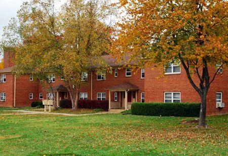 a red brick house with trees in front of it