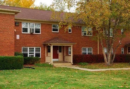 a red brick house with a tree in front of it