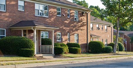 a brick house with a porch in front of a street