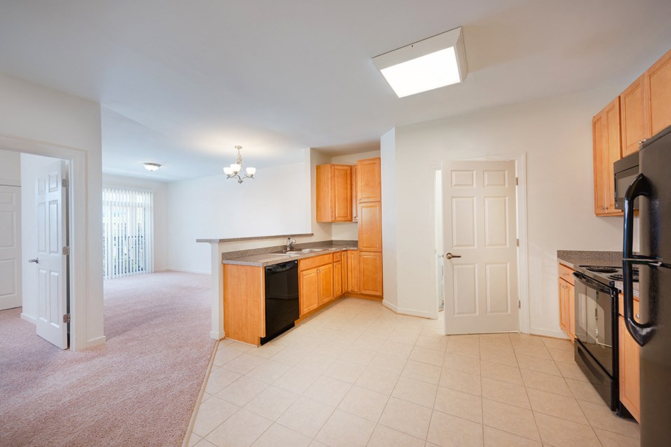 an empty kitchen with a door to the living room