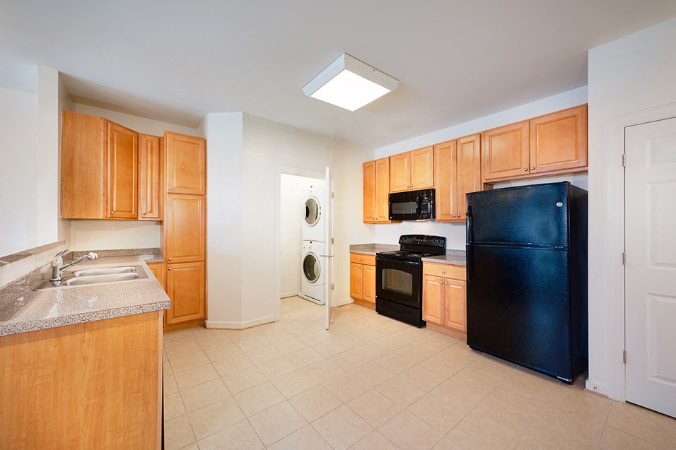 a kitchen with black appliances and wooden cabinets
