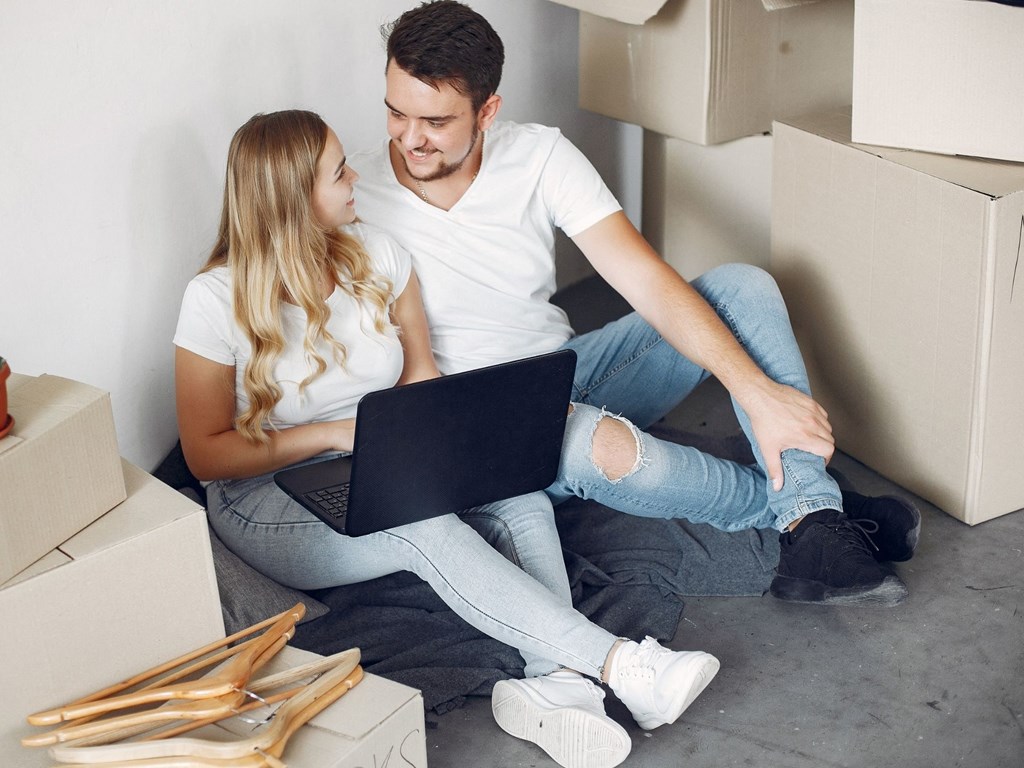 couple sitting on the floor with a laptop