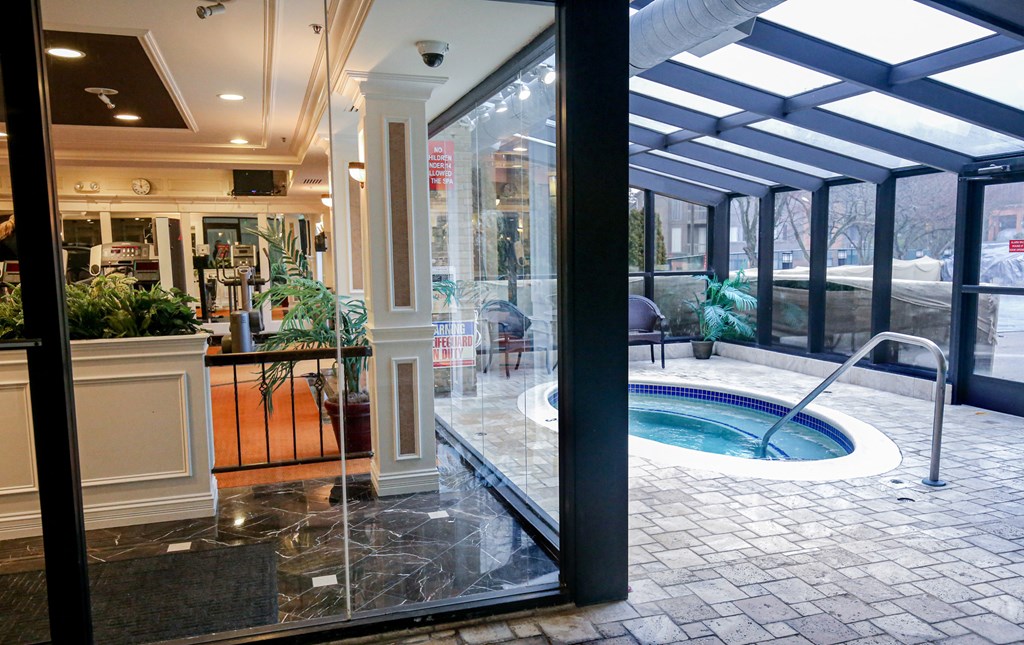 the lobby of a hotel with a jacuzzi pool and glass doors