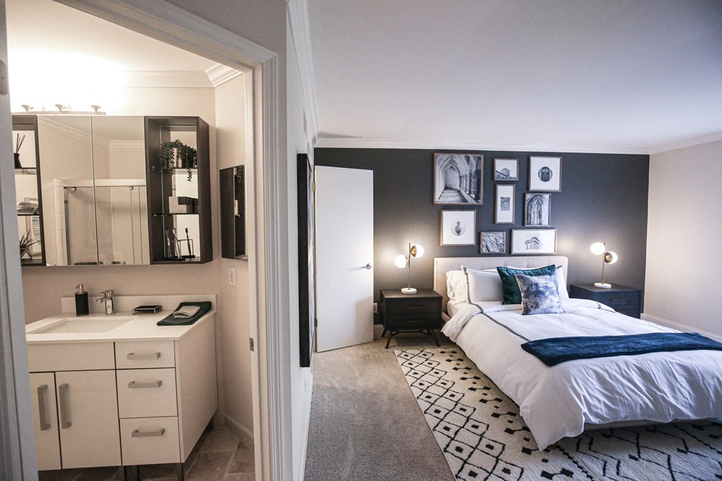 a bedroom with a bed and a sink and a mirror