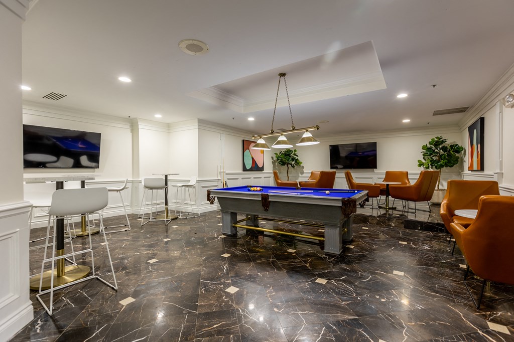a game room with a pool table and bar