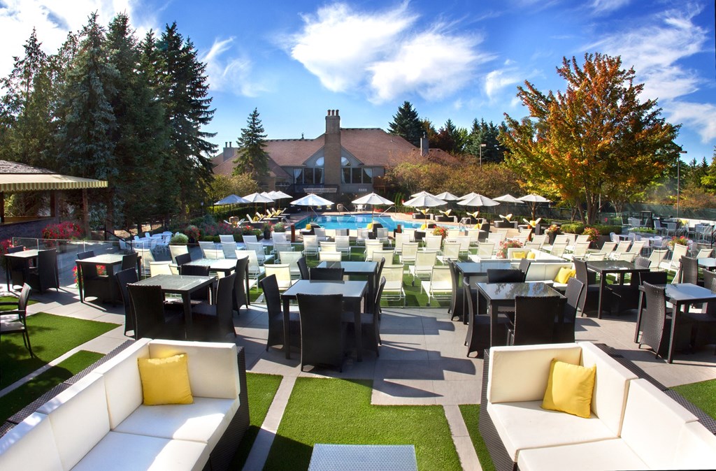 an outdoor patio with tables and chairs and a swimming pool