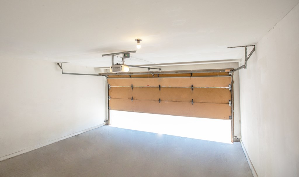 a garage door in a white room with a light on it