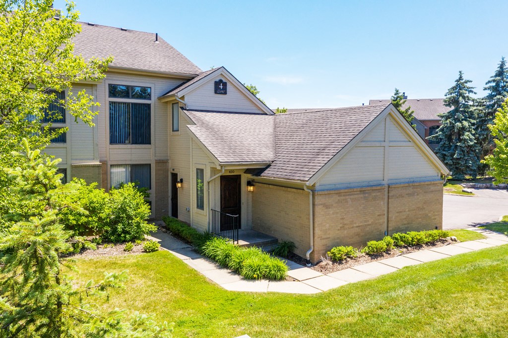a tan house with a sidewalk in front of it