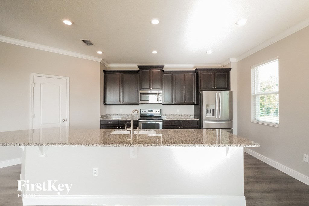 a kitchen with granite counter tops and black cabinets