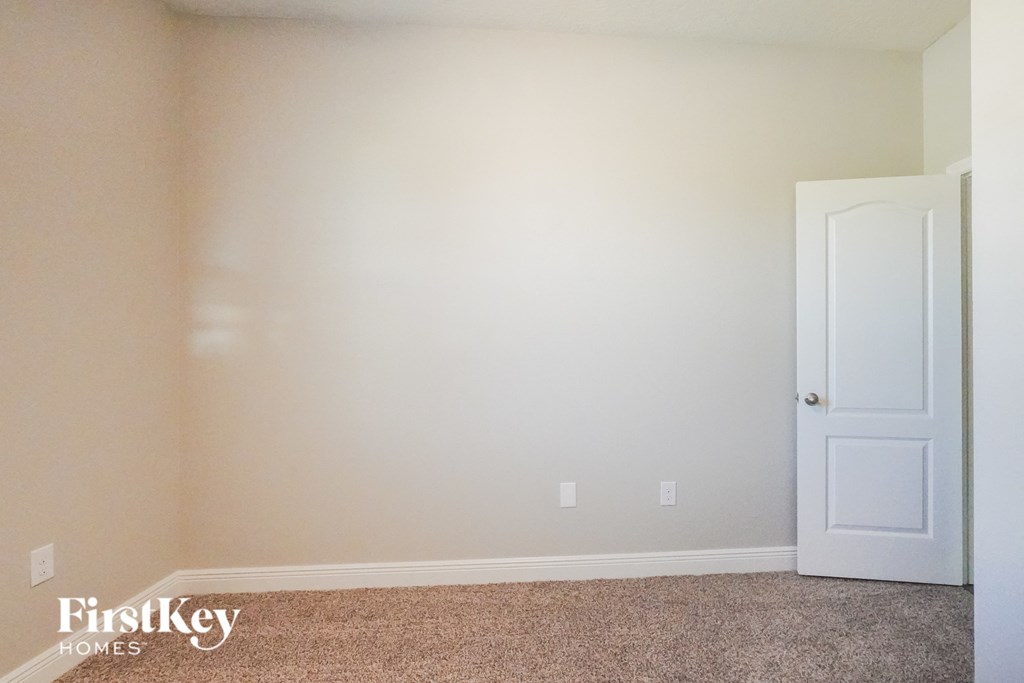 a bedroom with a white door and a carpeted floor