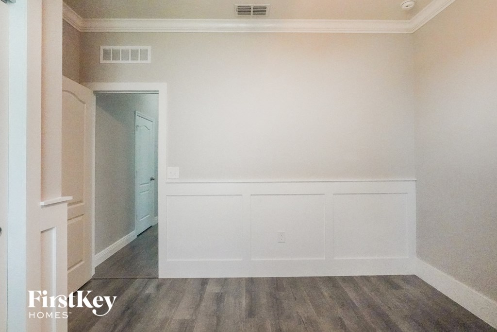 an empty room with white walls and wood floors