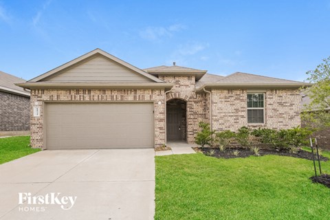 A house with a garage door and a driveway in front.