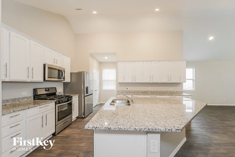 A kitchen with white cabinets and a granite countertop.