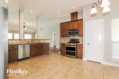 A kitchen with wooden cabinets and a tile floor.