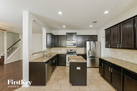 a kitchen with black cabinets and stainless steel appliances