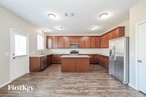 A kitchen with wooden cabinets and a refrigerator.