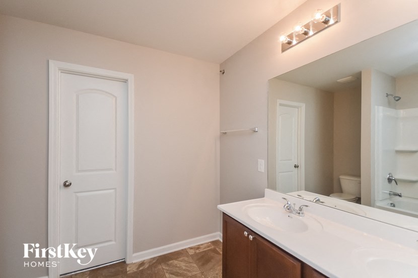 a bathroom with a large mirror and a white sink