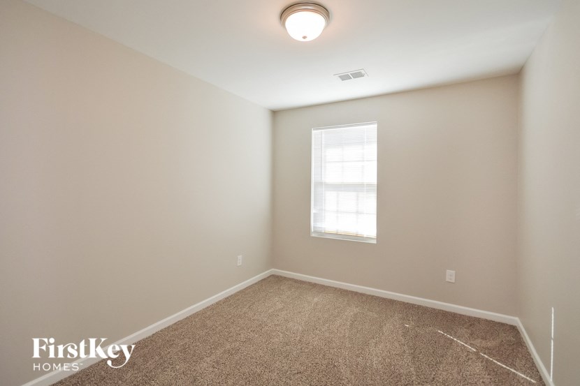 an empty room with a window and a carpet