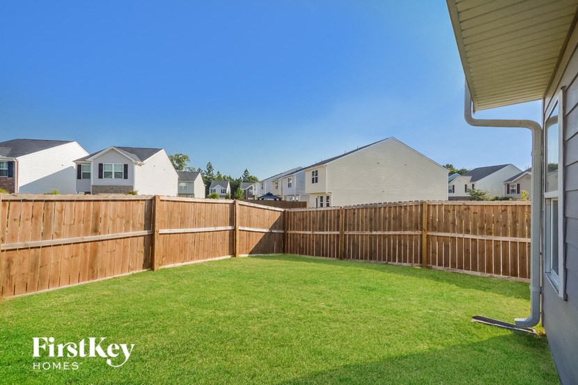 a backyard with a wooden fence and grass