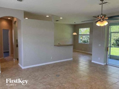 a large empty living room with a ceiling fan