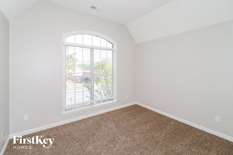 the second bedroom with carpet and a large window