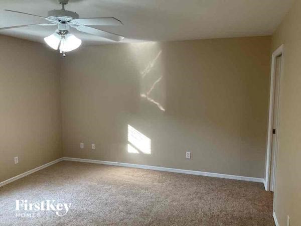 an empty living room with a ceiling fan