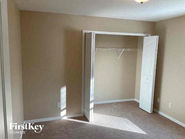 an empty bedroom with a closet and an open door