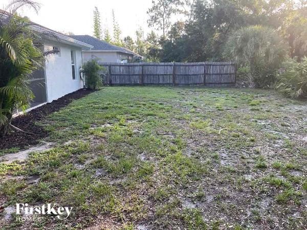 a backyard with a fence and a house