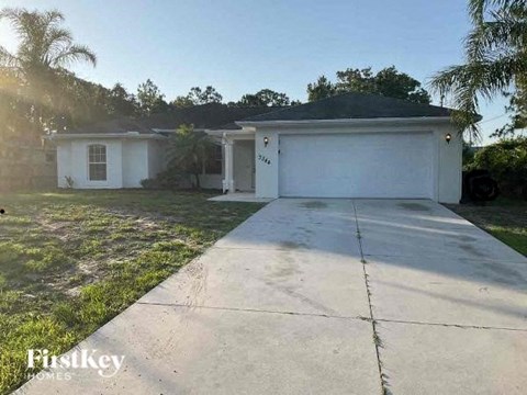 a white house with a driveway in front of it