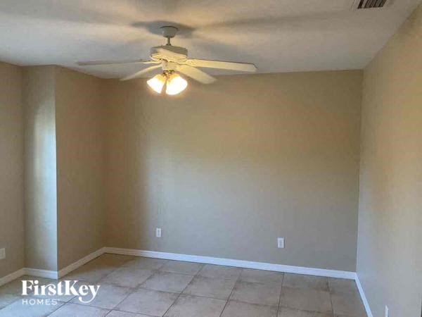 a empty living room with a ceiling fan