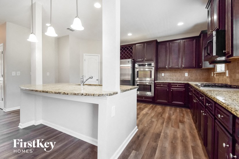a kitchen with dark wood cabinets and marble counter tops