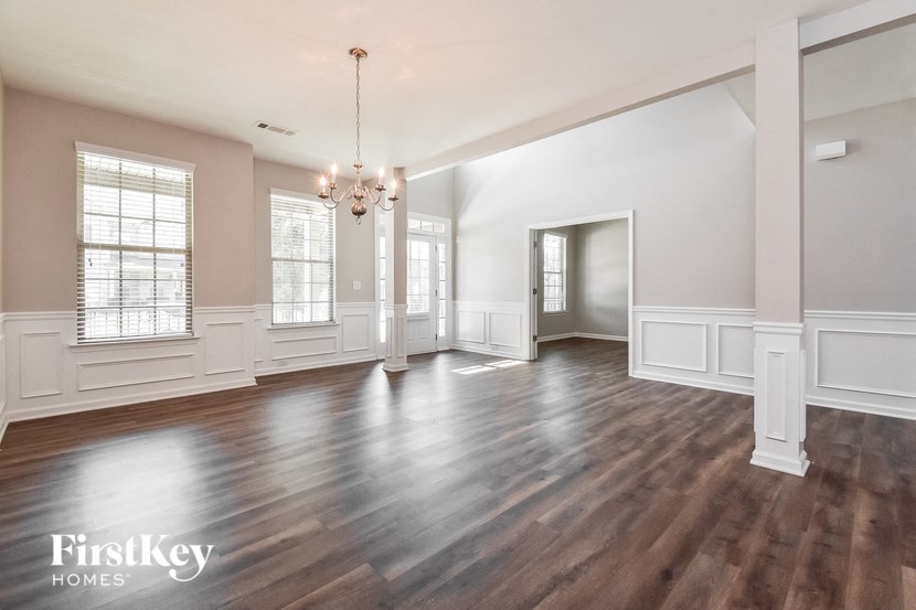 an empty living room with wood floors and white walls