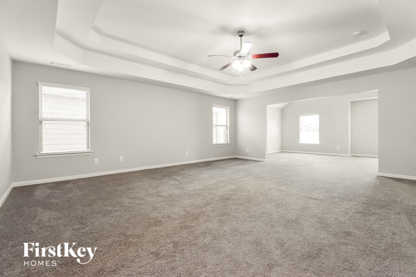 the living room of an empty house with a ceiling fan
