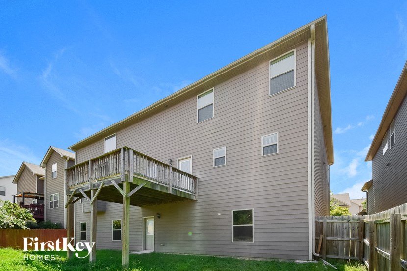 the outside of a house with a balcony and a yard