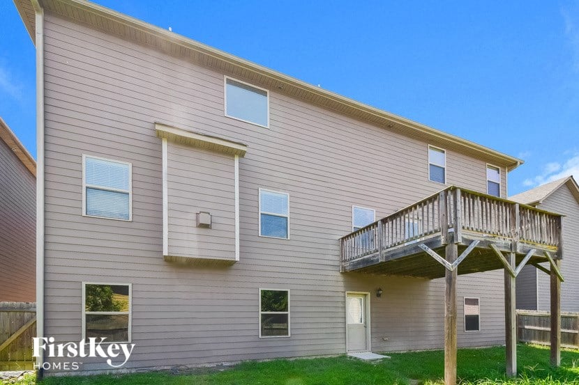 the outside of a house with a balcony and a deck