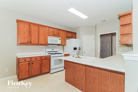 A kitchen with wooden cabinets and white appliances.