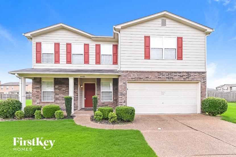 a white house with red shutters and a white garage door