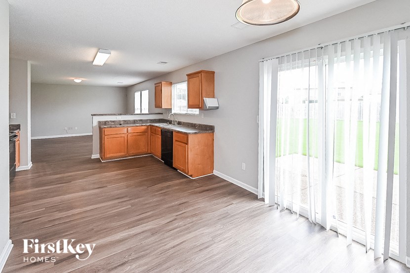 an empty kitchen with wood flooring and a sliding glass door