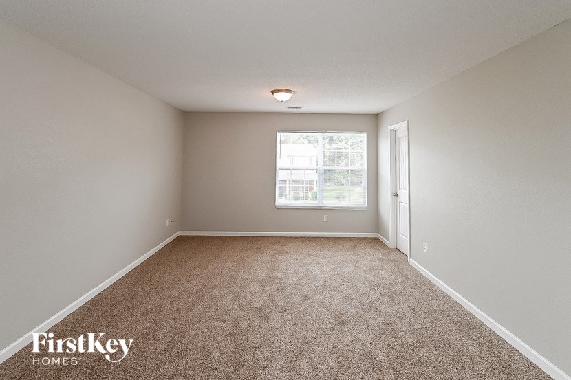 an empty room with carpet and a window