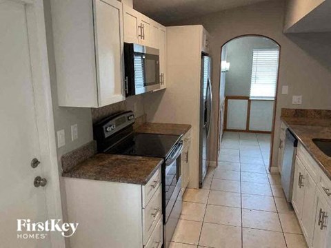 A kitchen with white cabinets and a granite countertop.