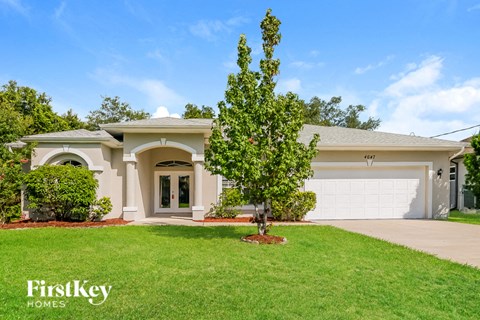 a house with a white garage door and a green lawn