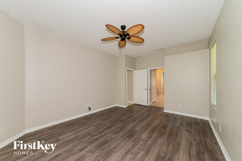 an empty living room with wood flooring and a ceiling fan