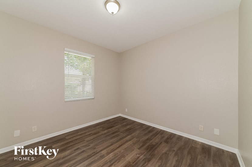 an empty room with wood flooring and a window