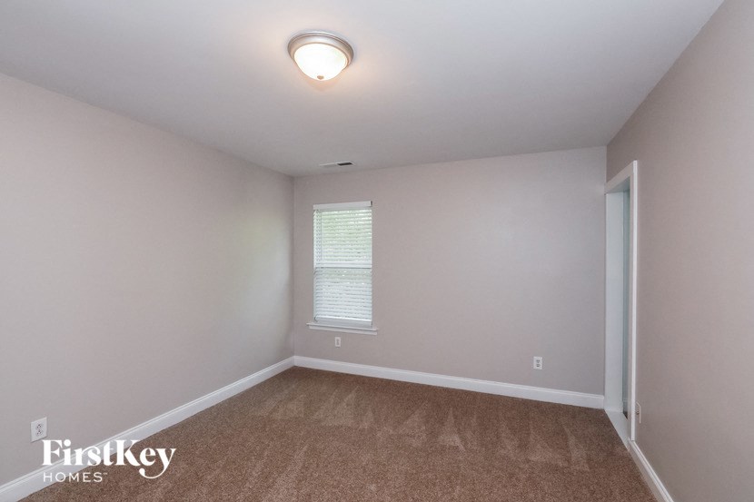 the bedroom with carpeted flooring and a door to the bathroom