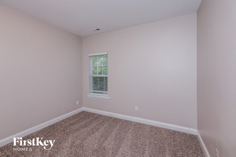a empty room with carpet and a window