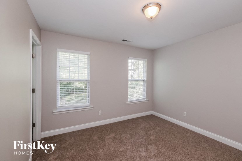 a bedroom with a carpeted floor and two windows