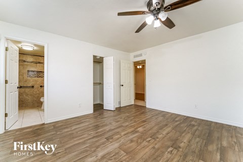 a living room with wood floors and a ceiling fan