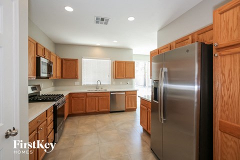 A kitchen with wooden cabinets and a stainless steel refrigerator.