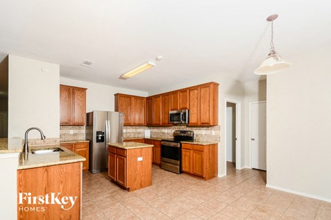 A kitchen with wooden cabinets and a refrigerator.