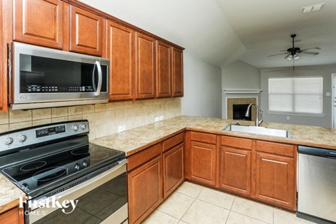 A kitchen with wooden cabinets and a black stove top oven.